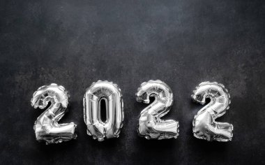 2022 yılının şişirilebilir gümüş sayıları koyu gri ya da siyah arka planda. Boşluğu kopyala.