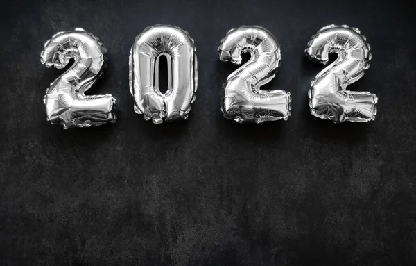 Koyu gri ya da siyah arkaplan üzerinde 2022 yılının gümüş sayıları. Boşluğu kopyala.