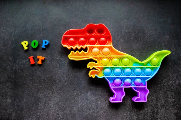 Speelgoed Pop Dinosaurus Regenboog Kleuren Een Zwarte Achtergrond Met Veelkleurige — Stockfoto