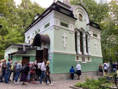 St. Petersburg, Rusya, Ağustos 2021: Smolensk mezarlığındaki Aziz Petersburg 'lu Xenia' nın mezarının üzerindeki kilise. Tapınakta ibadet etmek isteyen hacılar kuyruğunda. Hıristiyanlar duvarların yanında dua eder.