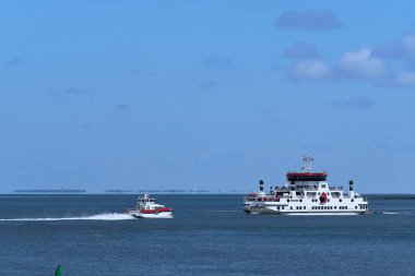 Waddensea, Hollanda-26 Nisan 2021: Hızlı feribot ve feribot Wadden Denizi 'nden Batı Frizya adası Ameland' dan Friesland 'daki Holwerd' e giden yolcularla birlikte..
