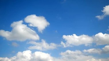 Mavi gökyüzünde küçük bulutlar oluşuyor ve kayboluyor. Uzakta uçaklar uçuyor.