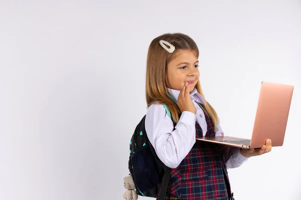 Fille heureuse portant l'uniforme, tenant un ordinateur portable, montrer bonjour, isolé sur fond gris. Concept d'apprentissage en ligne. — Photo
