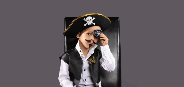 Classic captain pirate on a black leather chair for Halloween. Face painting for children. Isolated gray background with blank space. High quality photo
