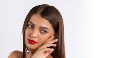 Banner, uzun format. Esmer kız. Kırmızı dudaklı güzel bir model yana bakıyor. Güzellik ve makyaj konsepti. Beyaz zemin üzerinde boş alan olan fotoğraf. Yüksek kalite fotoğraf