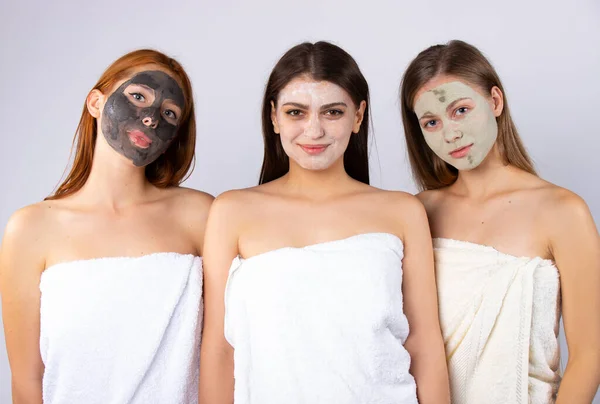 Trzy Młode Dziewczyny Maskach Pielęgnacji Skóry Owinięte Białe Ręczniki Uśmiechnięte — Zdjęcie stockowe