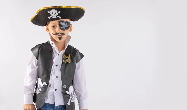  Yüzünde makyaj olan, korsan kostümlü dalgın bakışlı küçük bir çocuk. İzole edilmiş beyaz arkaplan