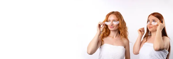 Banner, formato longo. Namoradas de cabelos vermelhos com engraçadinhas fofas embrulhadas em toalhas e manchas sob os olhos. Foto sobre fundo branco com grande espaço lateral — Fotografia de Stock