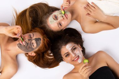 Farklı maskeli, salatalıklı ve mutlu gülüşlü arkadaşlarınız için rahatlama ve keyifli zamanlar. Sağlıklı cilt kavramı
