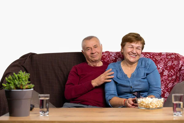 Ένα ηλικιωμένο ζευγάρι βλέπει μαζί ένα ενδιαφέρον πρόγραμμα στην τηλεόραση. Καλά να περάσετε και χαμογελάστε. Senior online και πανδημία έννοια. — Φωτογραφία Αρχείου