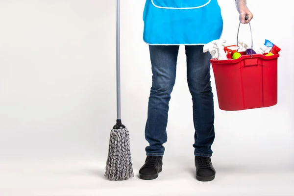 Gender equality. Legs of a man and in the hands of a mop and a bucket of cleaning supplies. Photo over white background with blank space. — Stock Photo, Image