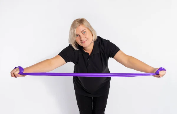 Sportieve Senior Vrouw Een Witte Achtergrond Strekt Een Fitness Elastische — Stockfoto