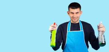 Lastik eldivenli yakışıklı ve elinde sprey silahla kameraya bakıyor. Fotoğraf beyaz arkaplanda ve boş yan boşluk. Cinsiyet klişeleri konsepti. Yüksek kalite fotoğraf