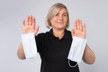 Bir kadın elinde tıbbi bir maske tutuyor ve durduğunu gösteriyor. Virüs konsept ve koruma önlemlerini yaydı. Yüksek kalite fotoğraf