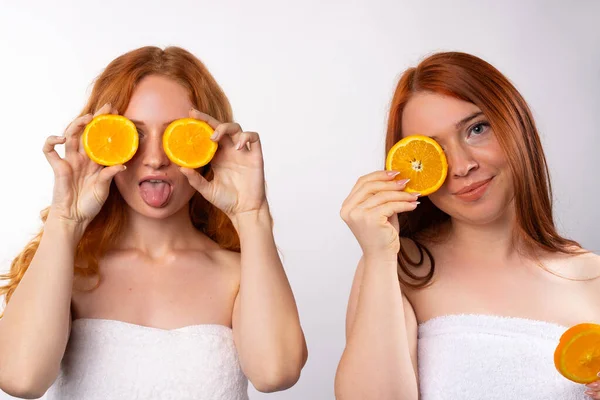 Дві Рудоволосі Дівчата Розважаються Позують Апельсиновими Скибочками Фото Білому Тлі — стокове фото