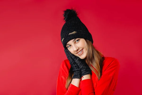 Uma Menina Bonita Sorri Posa Chapéu Inverno Luvas Fundo Vermelho — Fotografia de Stock