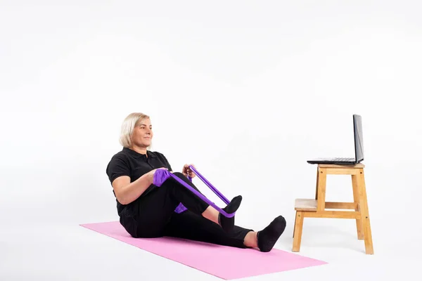 Mulher Sênior Sentada Tapete Fazendo Exercícios Com Uma Banda Elástica — Fotografia de Stock