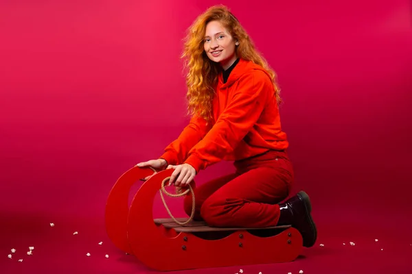 Χαμογελαστή Κοπέλα Που Κάθεται Έλκηθρο Κόκκινο Φόντο Χειμερινή Διασκέδαση Υψηλής — Φωτογραφία Αρχείου