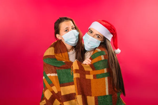 Namoradas Máscaras Médicas Envoltas Xadrez Posando Contra Fundo Vermelho Foto — Fotografia de Stock