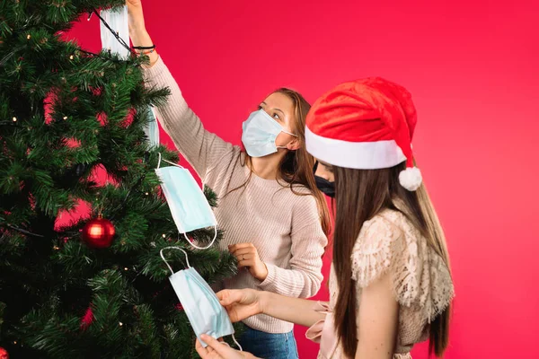 Kızlar Ağacı Tıbbi Maskelerle Süslüyorlar Tatil Salgın Hastalık Konsepti Yüksek — Stok fotoğraf
