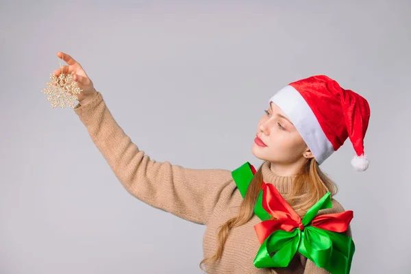 Nazik Bakışlı Bir Noel Kadını Altın Bir Kar Tanesine Bakar — Stok fotoğraf