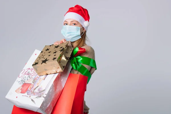 Senhora Uma Máscara Médica Chapéu Papai Noel Com Grandes Sacos — Fotografia de Stock