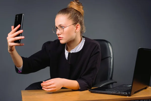 Serious Young Businesswoman Sits Computer Takes Selfie Smartphone Gray Background — Stock Photo, Image
