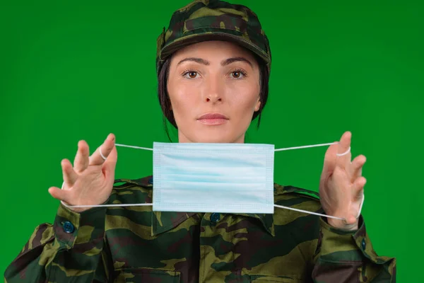 Una Mujer Seria Con Uniforme Militar Sostiene Una Máscara Médica — Foto de Stock