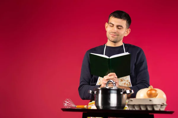 Cozinheiro Masculino Cozinha Livro Com Receitas Fundo Rosa Espaço Lateral — Fotografia de Stock