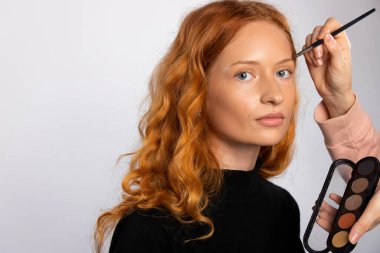 Kızıl saçlı bir kız için makyaj. Güzellik konsepti. Kozmetik fırça ve renk paleti, beyaz arka plan. Yüksek kalite fotoğraf