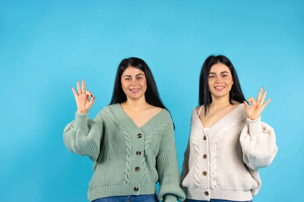 Meninas Morena Fundo Azul Gêmeos Mostram Tudo Sorrir Bonito Espaço — Fotografia de Stock