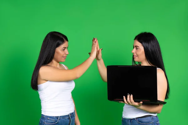 Mladé Úžasné Dvojče Sestry Notebookem Radují Jejich Úspěchu Zeleném Pozadí — Stock fotografie