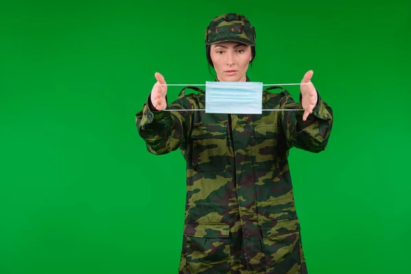 Una Mujer Con Uniforme Militar Sostiene Una Máscara Médica Frente — Foto de Stock