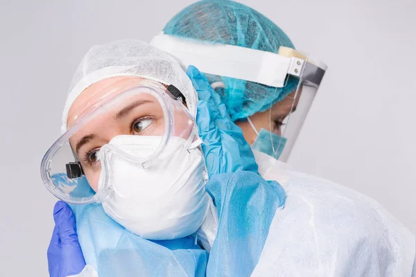 Koruyucu giysili yorgun doktorlar salgın sırasında birbirlerine sarılıp destek oluyorlar. Virüsle savaşıyorum. Yüksek kalite fotoğraf