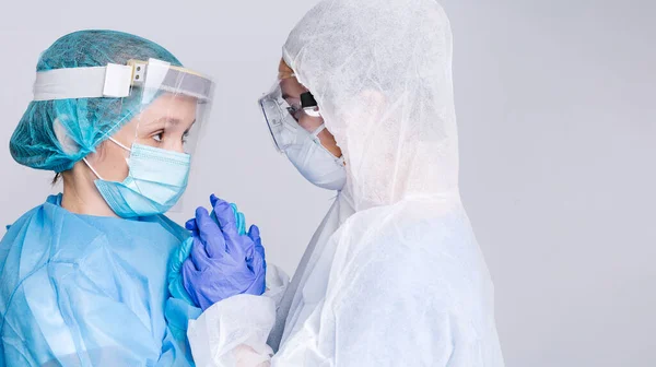 Koruyucu ekipmanlarda çalışan yorgun sağlık görevlileri salgının zorlu döneminde 19 kişi el ele tutuşup destek verdi. Yüksek kalite fotoğraf