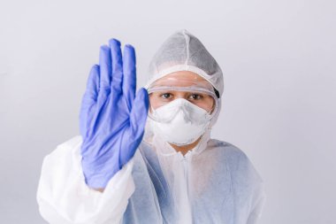 Koruyucu ekipmanlardaki doktor kameraya virüsün beyaz arka planda yayılmasını durdurduğunu gösteriyor. Yüksek kalite fotoğraf