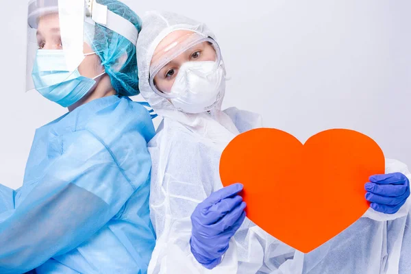 Enlarged photo of tired doctors with a big red heart on a white background. High quality photo