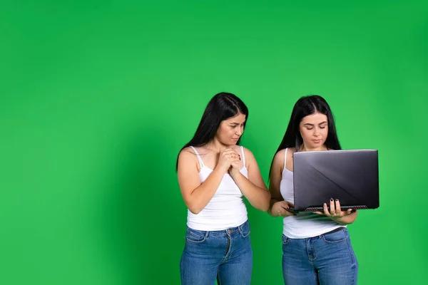 Chicas gemelas con ordenadores portátiles. Vieron algo interesante allí. Espacio lateral vacío. — Foto de Stock