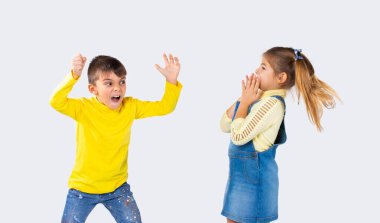 Anaokulu çocuğu beyaz arka plandaki kız arkadaşını korkutuyor. Duygular konsepti ve çocuklar tarafından harcanan zaman.