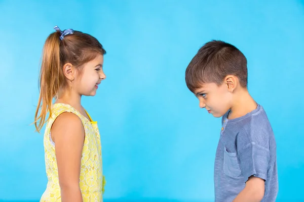 Emociones de los niños preescolares que se miran a los ojos. Foto sobre fondo azul. — Foto de Stock