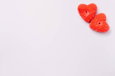 Köşede kırmızı kalp şeklinde mumlar var. Gri arka planda. Reklamınız için boş yer var..