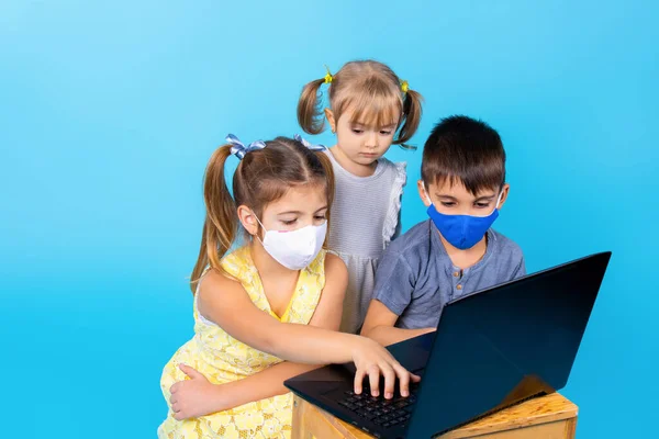 Діти в медичних масках спілкуються через відеозв'язок. Поняття нових норм . — стокове фото