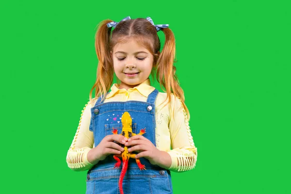 Retrato de una chica sosteniendo un lagarto. Fondo verde. Concepto de mascotas. — Foto de Stock