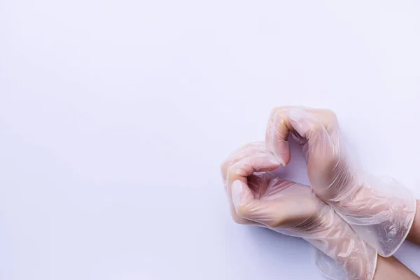 Läkare händer i handskar gör en hjärtform isolerad på vitt med massor av tomt utrymme. — Stockfoto