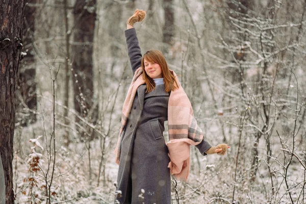 Menina feliz em uma floresta de inverno sorrindo e posando com os braços para os lados. — Fotografia de Stock