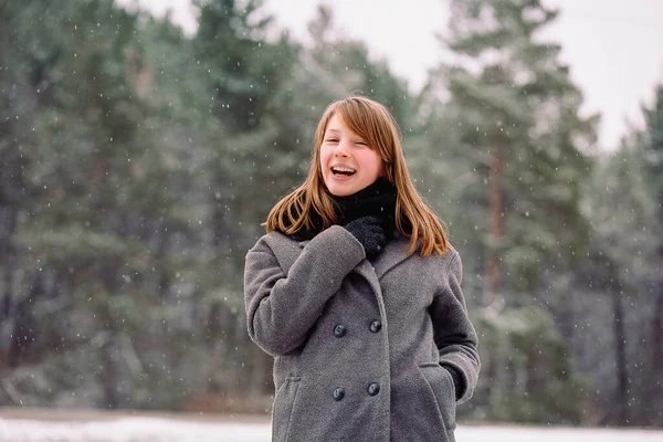 Émotions heureuses d'une jeune fille rieuse en gants et d'une écharpe chaude dans la forêt gelée hivernale. — Photo