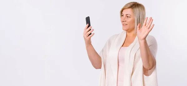 Banner. Ung kvinna kommunicerar genom videokommunikation på en smartphone. Nya normer och virtuell kommunikation på en vit bakgrund. — Stockfoto
