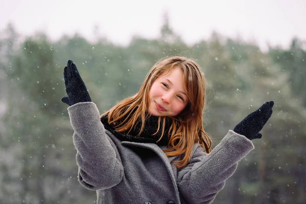 Retrato de uma menina sorridente que posa e se diverte na floresta de inverno. — Fotografia de Stock