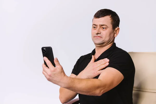 Senior hard of hearing man communicates via video call using non-verbal gestures. White background.