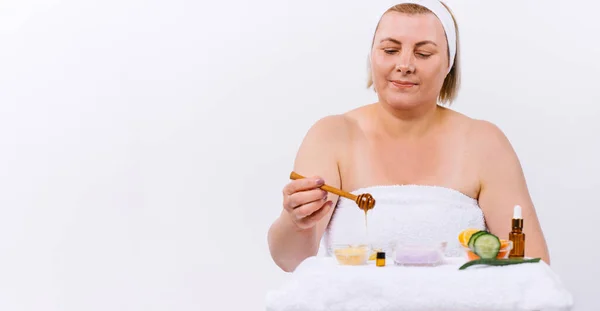 Banner,long format. Focused senior woman preparing honey mask over white background. Homemade beauty product — Stock Photo, Image